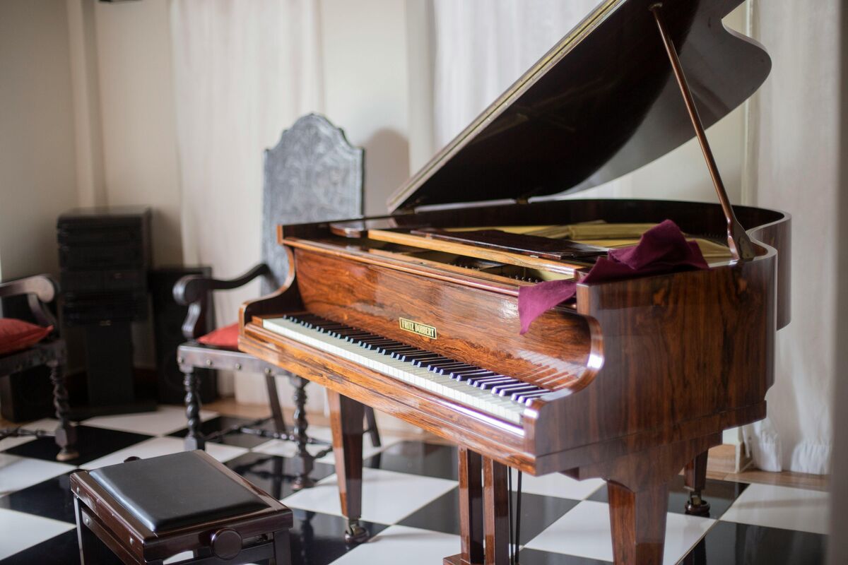 A beautiful grand piano in an elegant room, lid open and ready to play